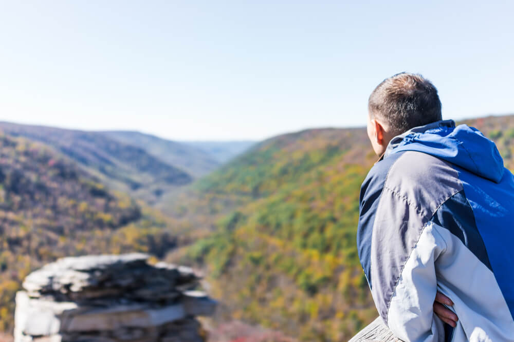 Man overlooking the West Virginia Mountains, one of the best bucket list ideas.